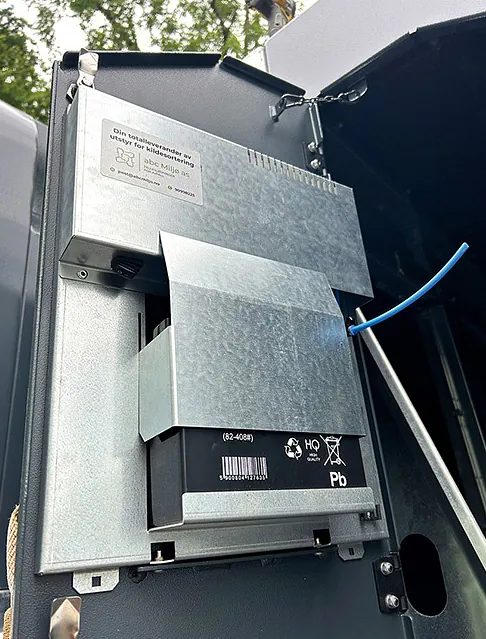 Montert ozon-enhet med batteriboks og synlig blå ledning, installert i container for desinfeksjon.