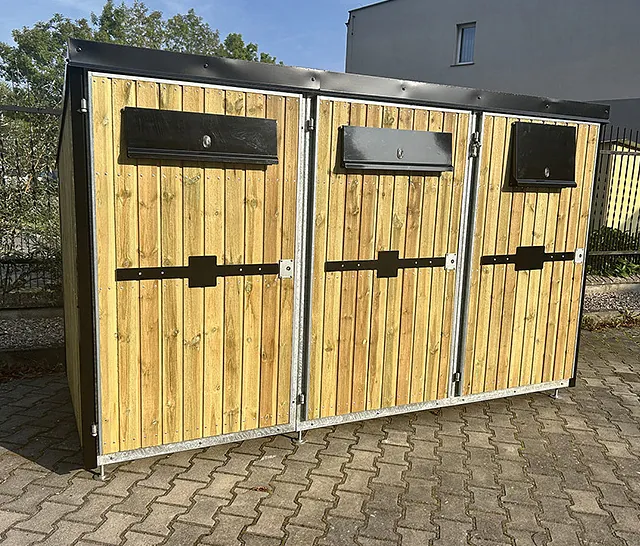 Skapmodul med mørk kledning sett fra skrå vinkel, viser buet tak og fem separate kasteåpninger med låsbare luker.