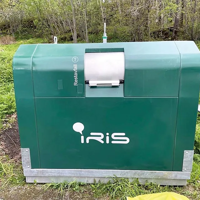 OWS Skandinavia-container for restavfall i grønn utførelse, merket med IRIS-logo og plassert i grøntområde.