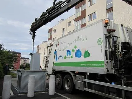 Kranbil som tømmer en fullt nedgravd avfallsbrønn via bunntømt system fra ABC Miljø i et boligområde.