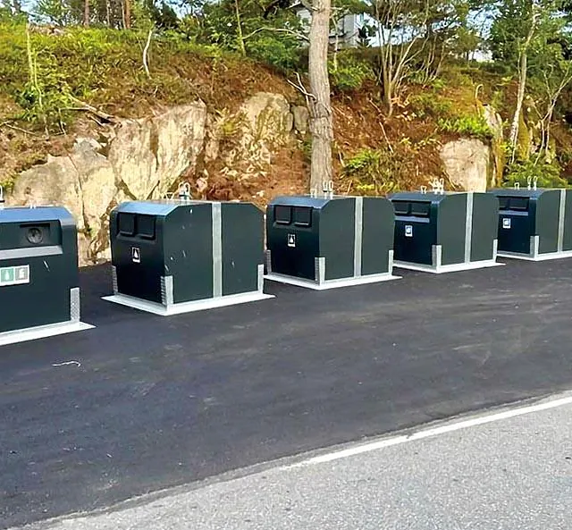 Flere semi-nedgravde beholdere installert i naturskjønt område.